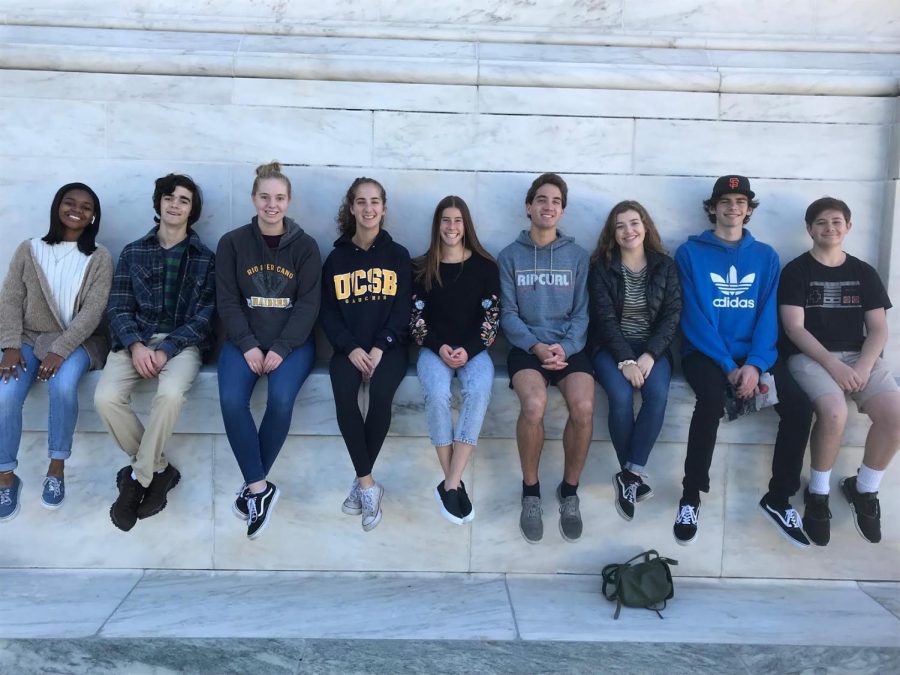 [left to right] Synia Thrower, Joseph Bender, Jessica Sheppard, Annalee Gorman, Katie Newton, Nicolas Gorman, Emma Hutchinson, Mickey Doolittle, Luke Richards sit on the outside of the United States Supreme Court.