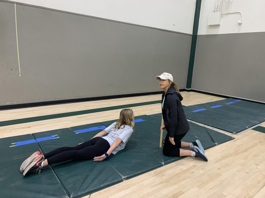 P.E. teacher Shawna Virga measures a students performance in the trunk lift exercise.