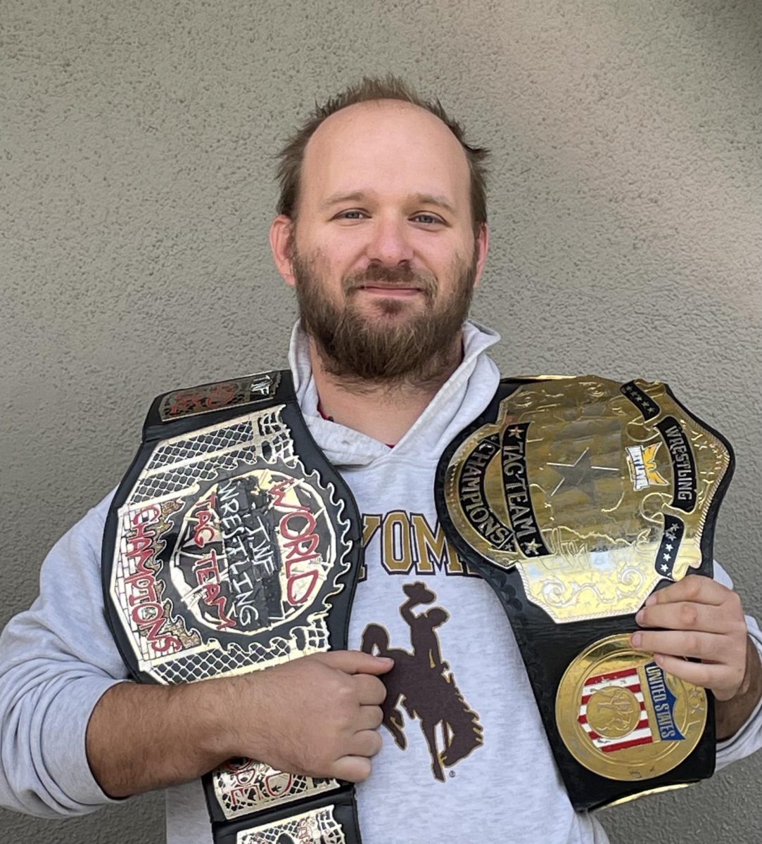 Austin Bell holding his champion belts.