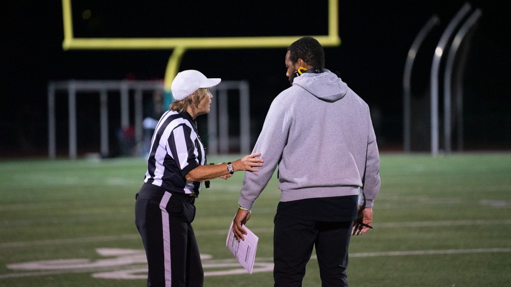 Reid talking with a referee at a game. He took Rio from a 1-8 record before his tenure to a 9-3 record in his final seson.