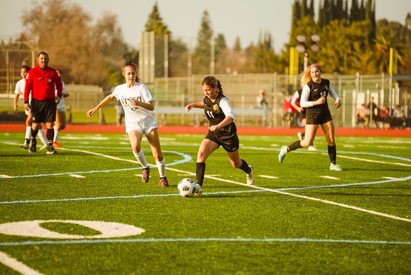 Junior Raegan Rossi dribbles the ball in a game earlier in the season. The girls soccer team won their league title.