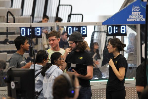 Robotics team project manager Micah Newcomer (second from right) works with his team during a competition. Photo provided by him.