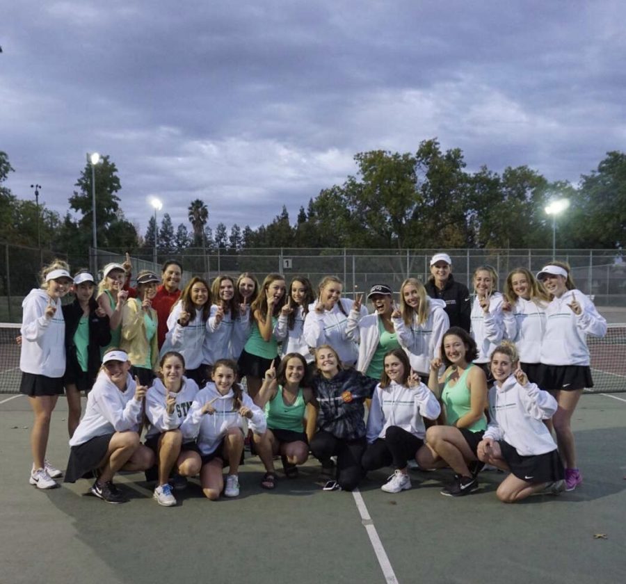 Women’s varsity tennis hold up the number one as they finish first in league play Oct. 19.