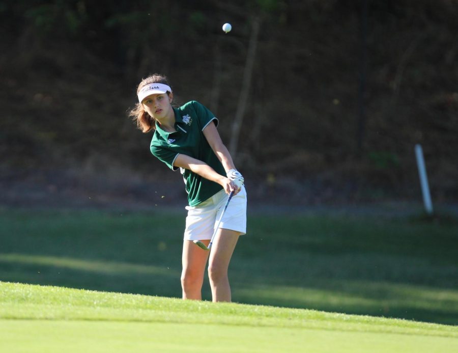 Junior Katelyn Kamilos chips the ball out of the rough. Photo by Ed
Mahone.