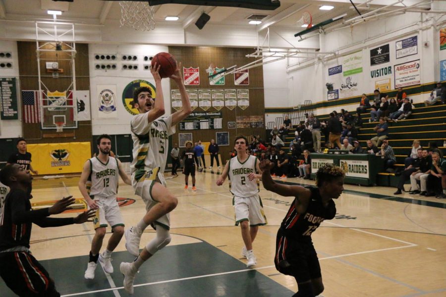 Junior Jonah Roth goes up for a lay up while seniors Matthew Dixon and Cade Johnson look for a put back.