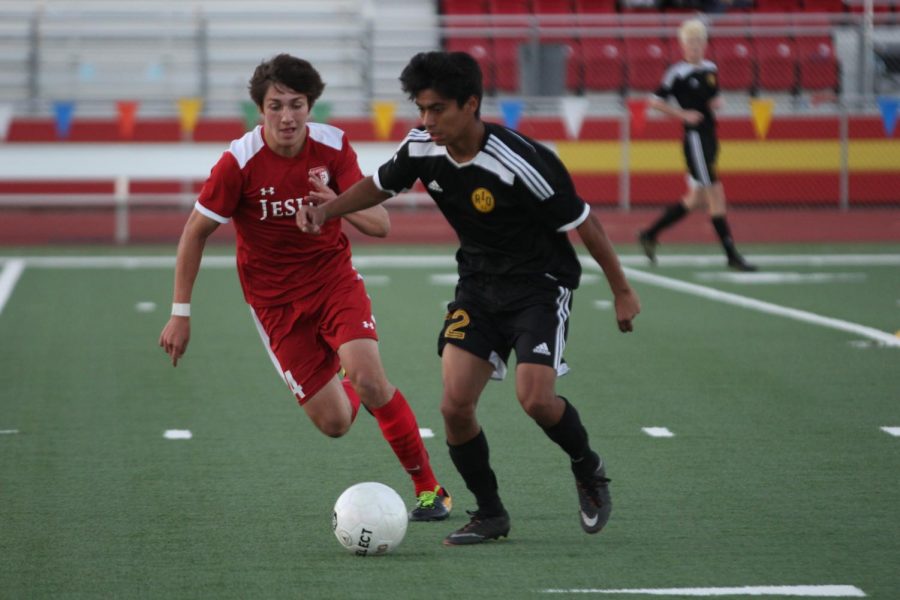 Sophomore Steven Barreto holds off the defender whiling looking for an open teammate to pass the ball to against Jesuit.