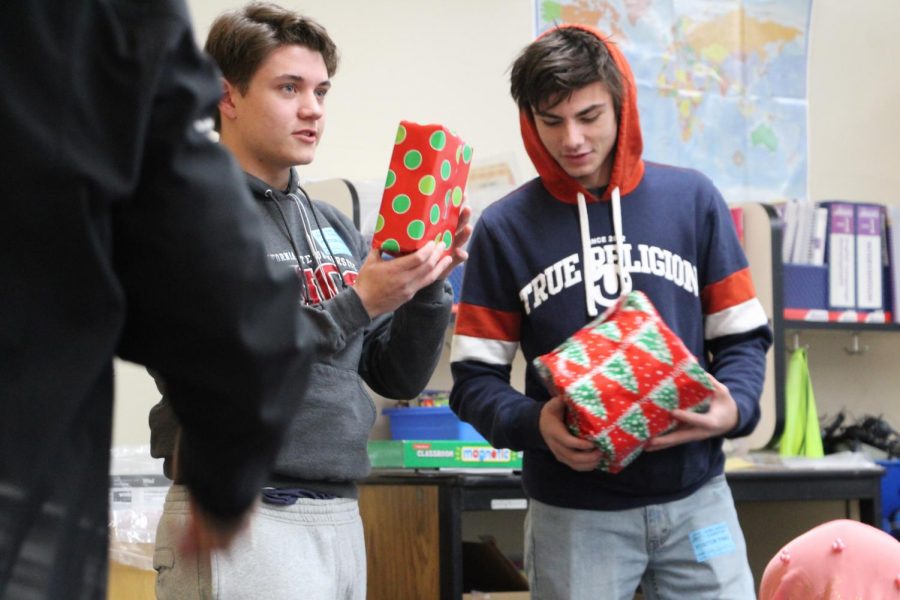 Seniors Sean Remitz and Cody Rister give presents to students at Howe Avenue Elementary school. Photo by Kaitlyn Shellooe.